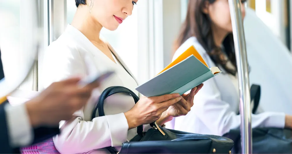 通勤電車で読書する女性